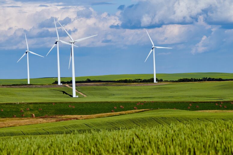 Four wind turbines turn and produce renewable energy for local houses