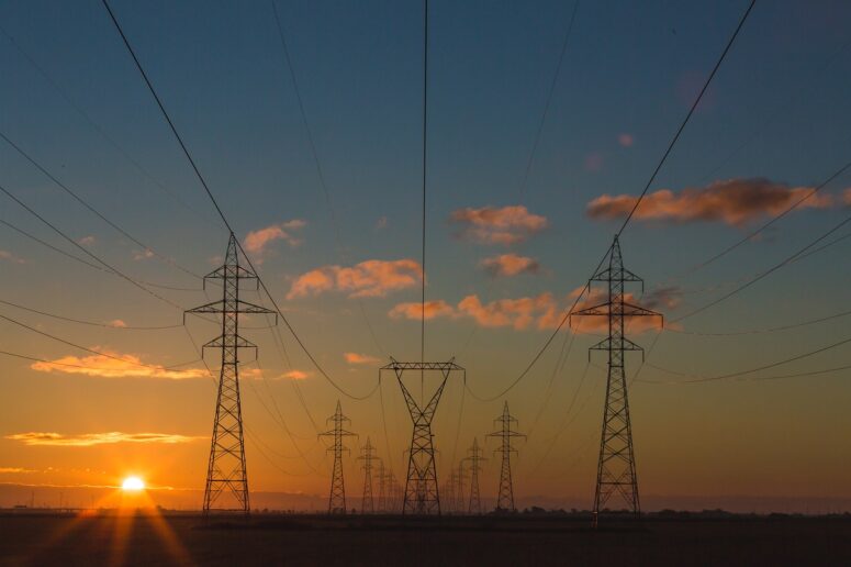 Power lines run across a field in the UK. This is where any waste energy that isn’t stored by diverters goes.