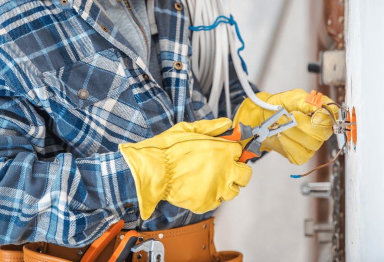 An electrician fixing and maintaining electric sockets within a home after becoming a qualified electrician.