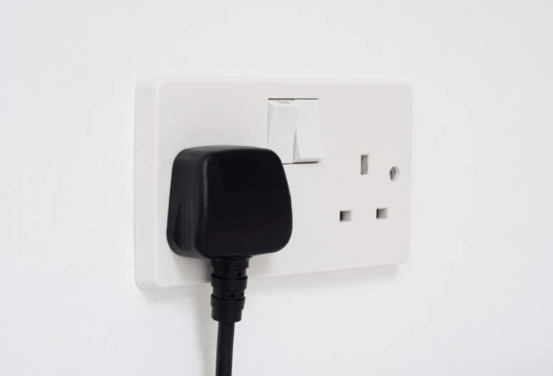 A plug-in wall socket being operated correctly in a rental property after the landlord passed their electrical safety training.