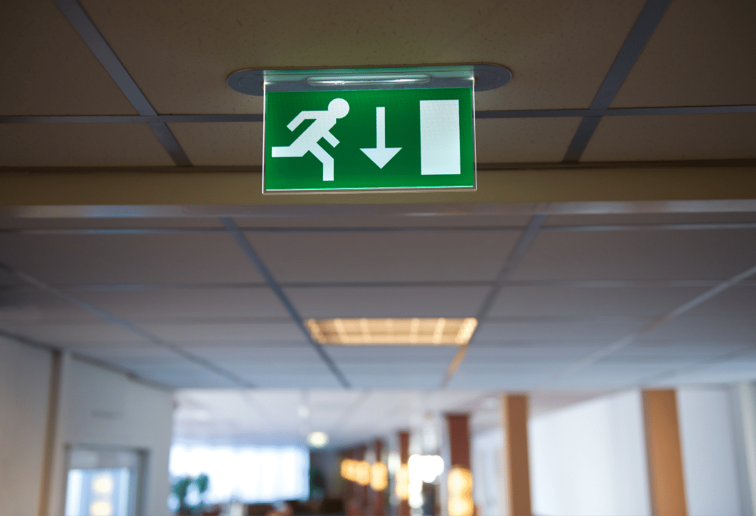 An image of a green emergency lighting signboard installed by an electrician in a hospital, emphasising its critical role in saving human lives during emergencies.